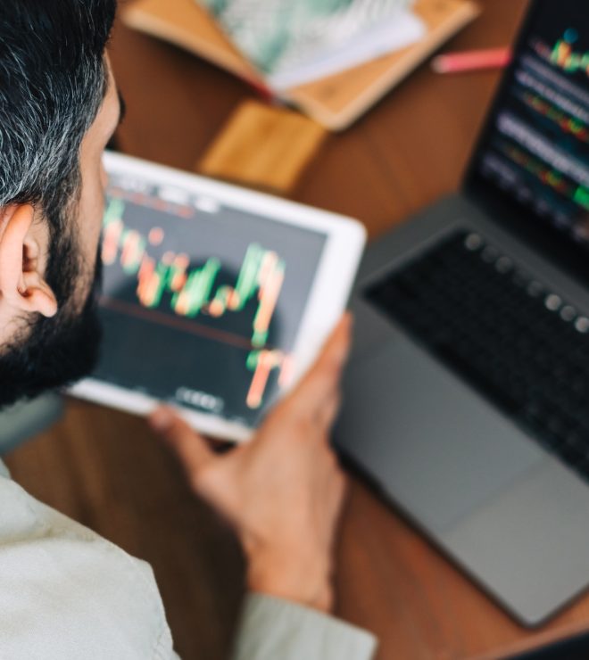 Caucasian businessman trading online, using computer technology, looking on stock exchange